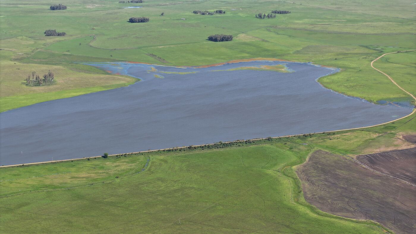Barragem da Estância El Rincón cercada por campo e área de lavoura
